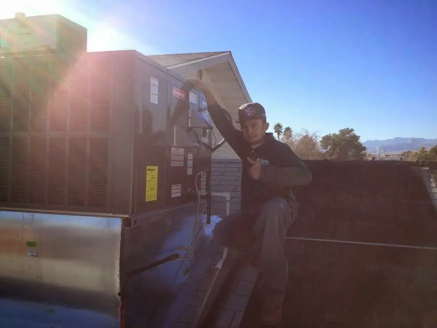 HVAC technician performing Heat Pump Repair on a rooftop unit in Dundalk